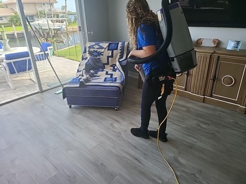 Technician using backpack vacuum to clean smoke residue from waterfront home
